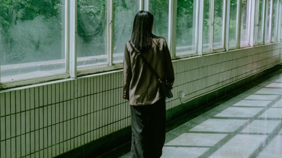 Kvinde bagfra står i lang gang