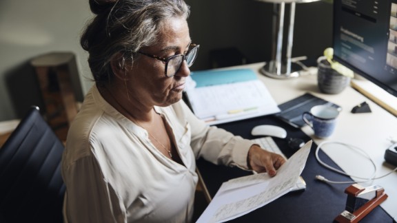 En kvinde med en arm sidder med et stykke papir